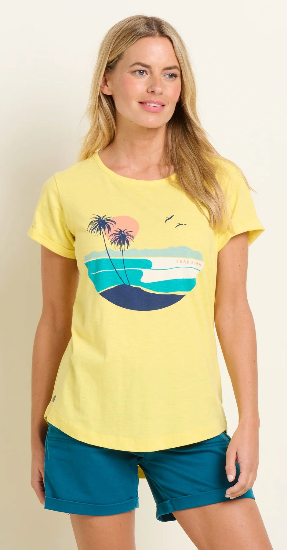 Brakeburn women's short sleeve Shore t-shirt in yellow with a coastal print on the front with sun, sea and palm trees.