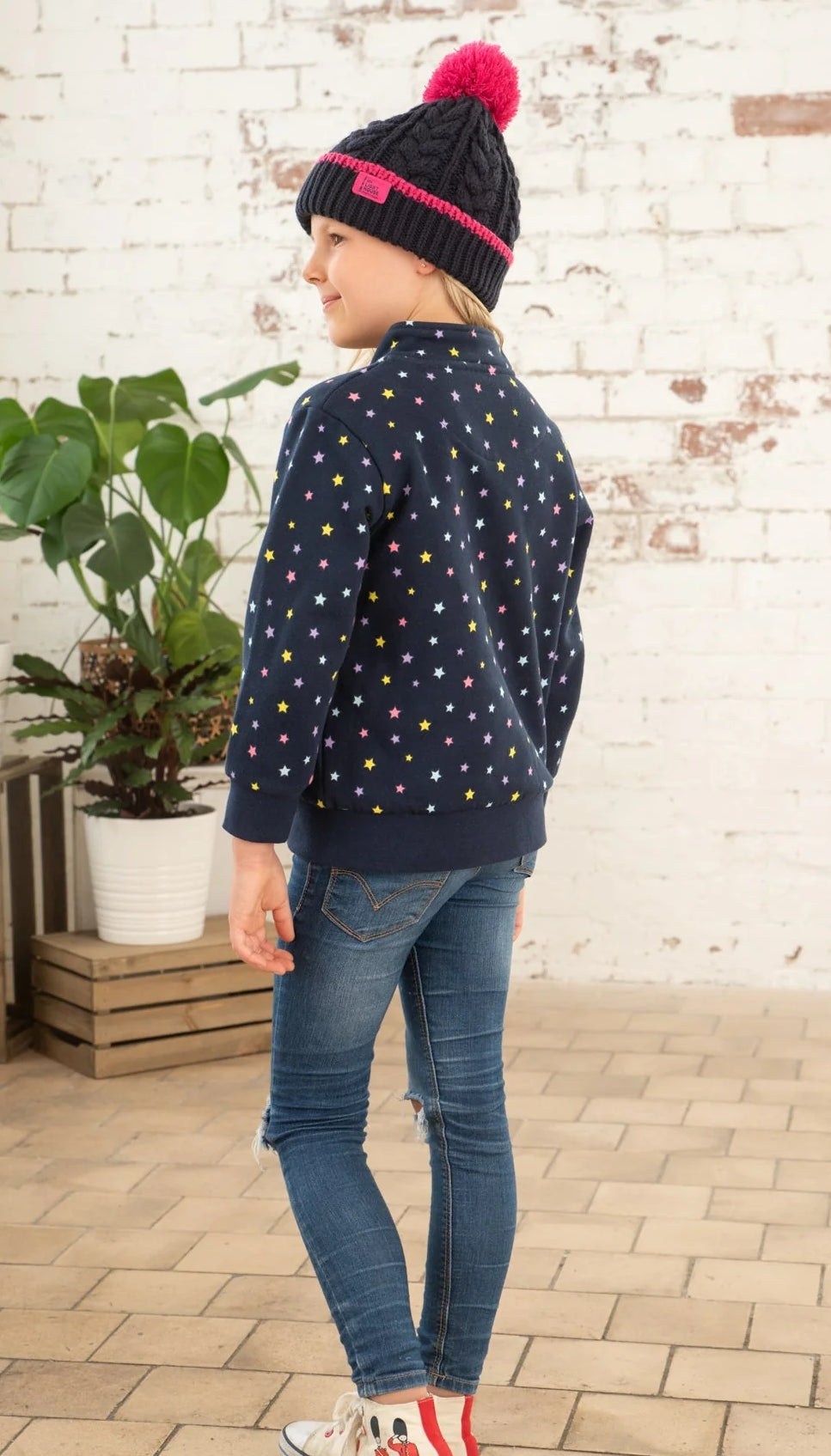 Kids Ava sweatshirt from Lighthouse in Navy with full zip, multicoloured star print, tummy pockets and elasticated cuffs and bottom hem.