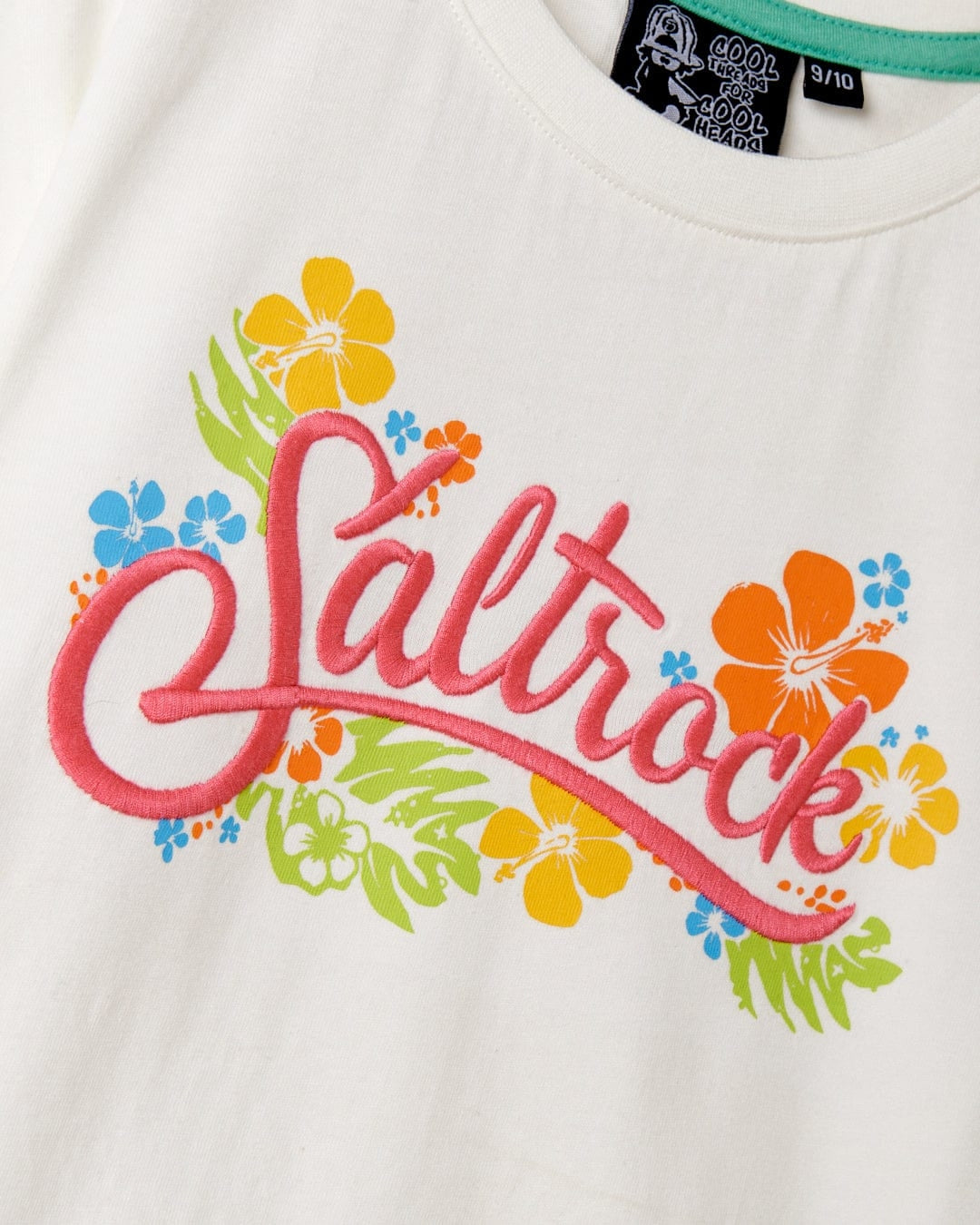 Kids tee from Saltrock in white featuring a multicoloured tropical floral print and embroidered logo on the front.